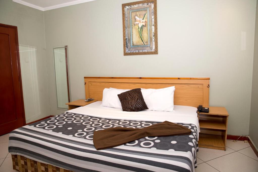 a bedroom with a bed with a black and white blanket at Taka-Taka in Maputo