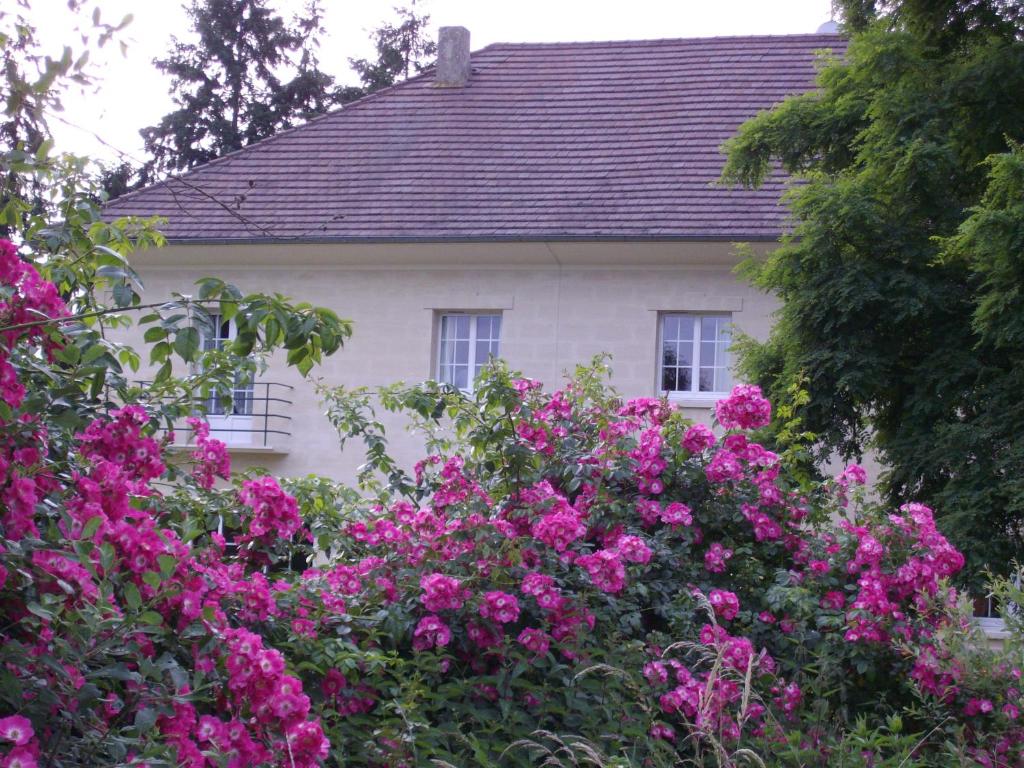 ein Haus mit rosa Blumen davor in der Unterkunft Domaine de Beauvilliers in Chaumontel