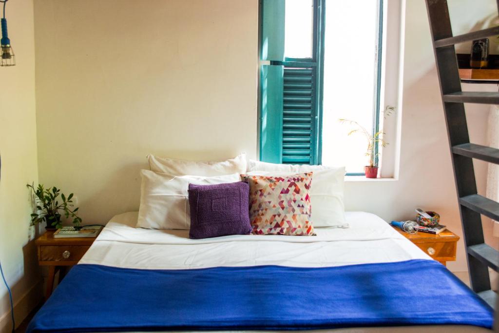 a bedroom with a bed with pillows and a ladder at Hospedaria Rio in Rio de Janeiro