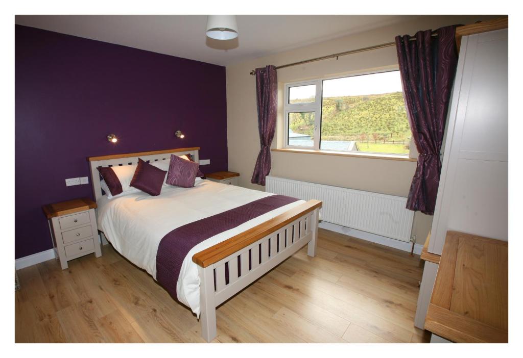 a bedroom with a large bed and a window at Ash Lodge in Moytirra