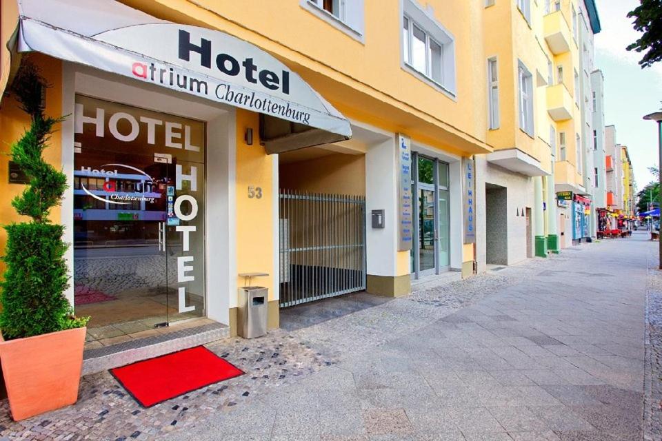 a hotel building with a red mat in front of it at Hotel Atrium Charlottenburg in Berlin