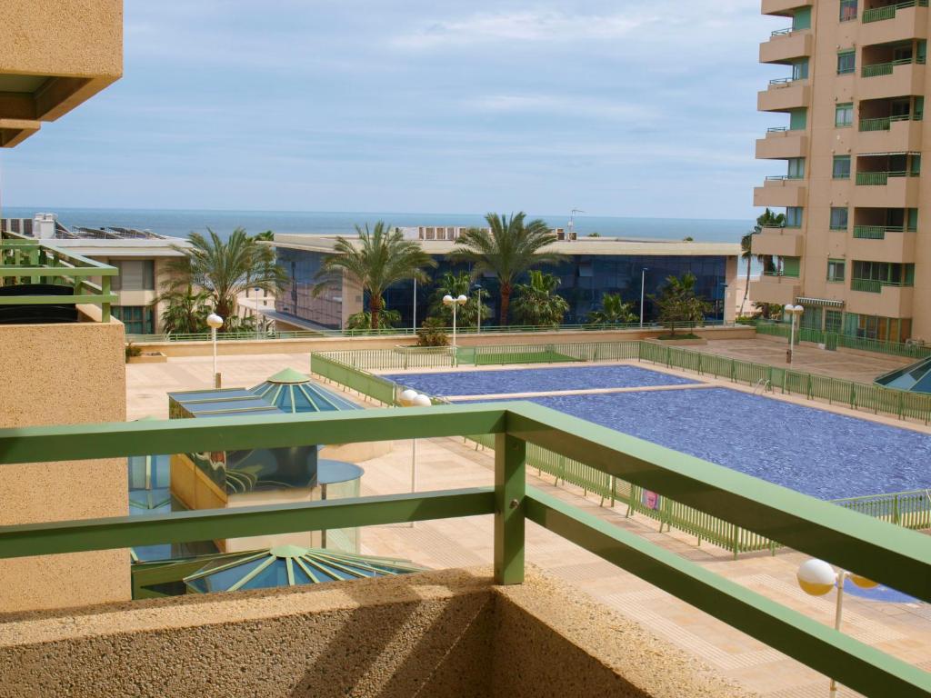 バレンシアにあるApartUP Patacona Beach IIの建物のバルコニーからスイミングプールの景色を望めます。