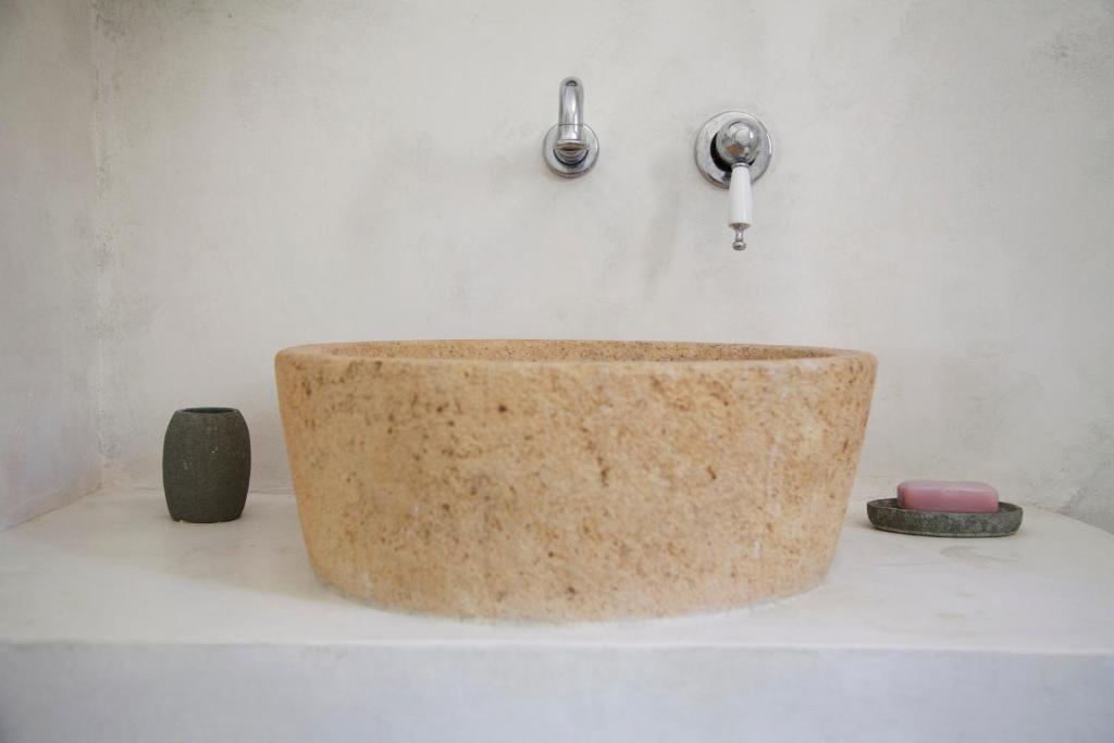 a bathroom with a stone sink and a faucet at Luxury house in the island of Patmos in Grikos