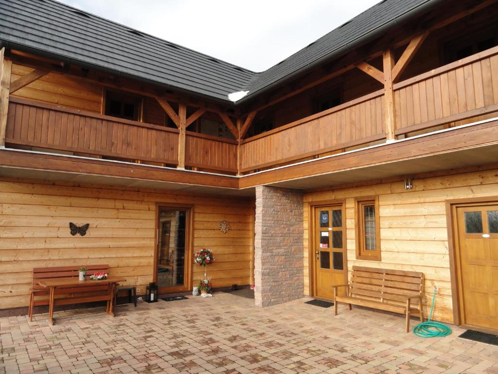 ein Holzhaus mit zwei Bänken auf einer Terrasse in der Unterkunft Penzion Žumberk in Nové Hrady