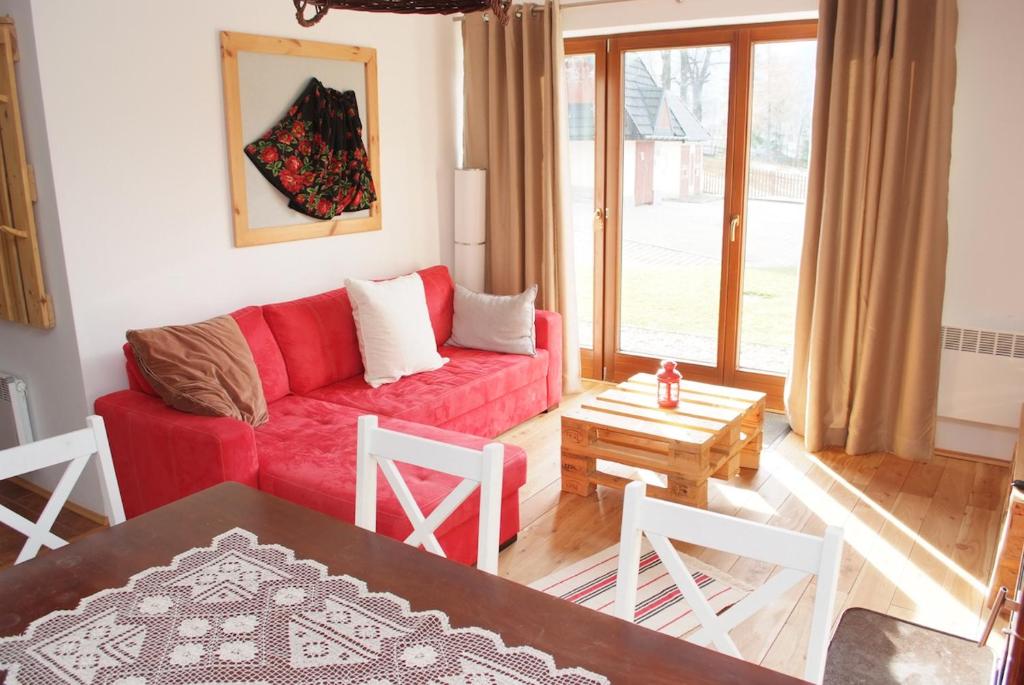 コシチェリスコにあるZakopanerentのリビングルーム(赤いソファ、テーブル付)