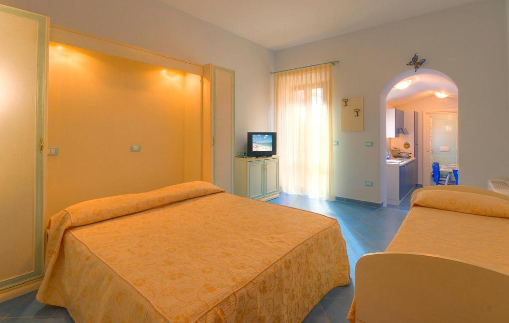 ein Hotelzimmer mit 2 Betten und einem TV in der Unterkunft Butterfly's House in Porto Recanati