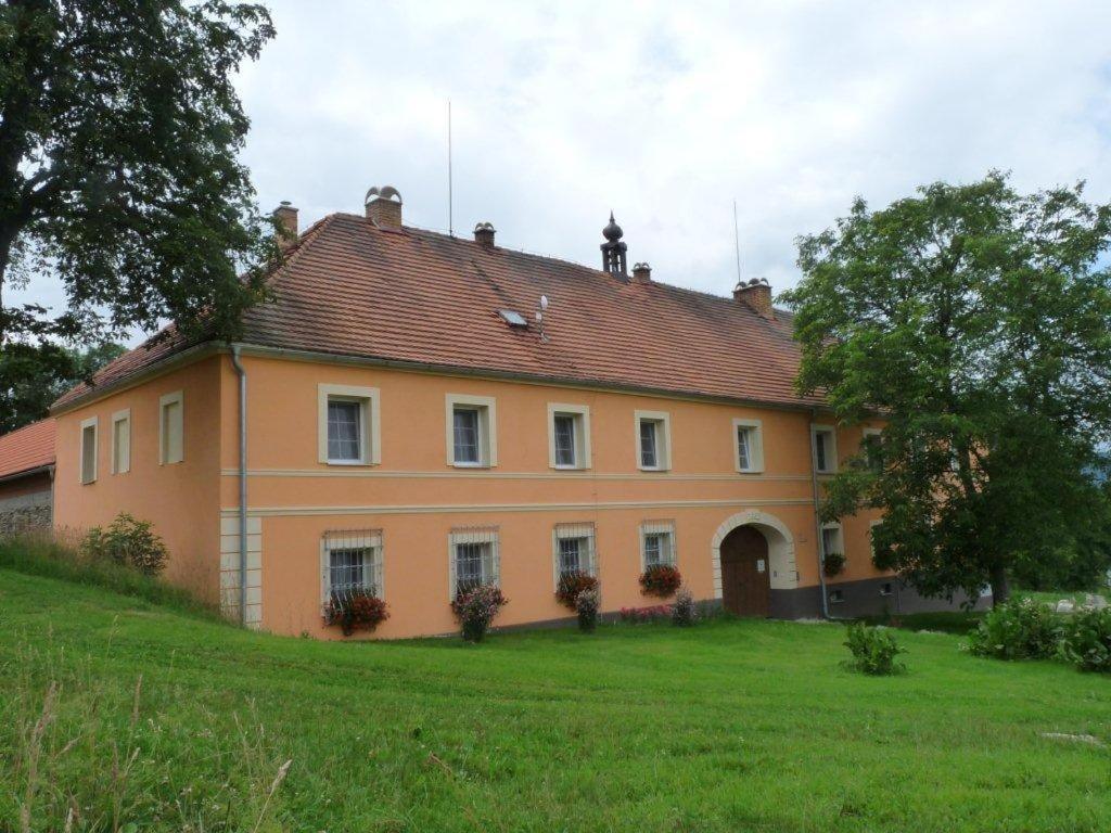 una gran casa naranja en un campo verde en Statek Kloubek, en Chabičovice