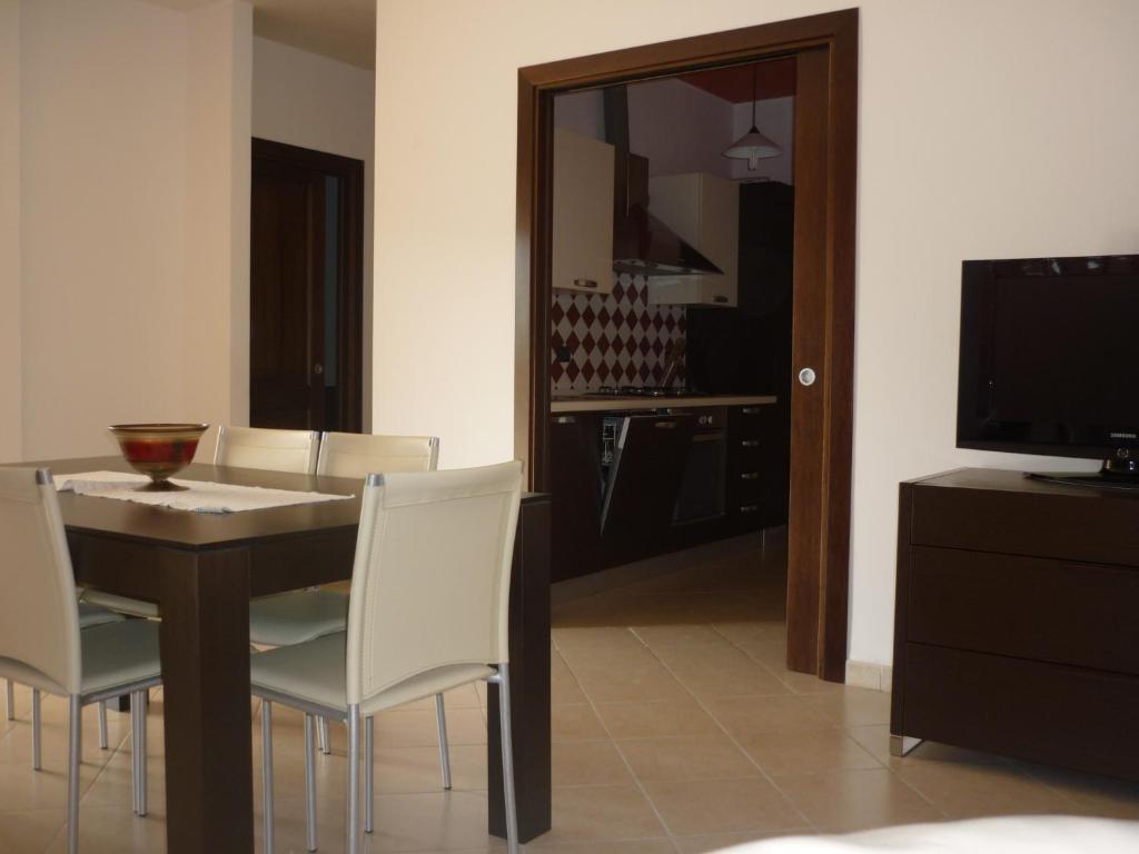 jadalnia ze stołem, krzesłami i telewizorem w obiekcie Casa vacanze da Anna w mieście Tortolì