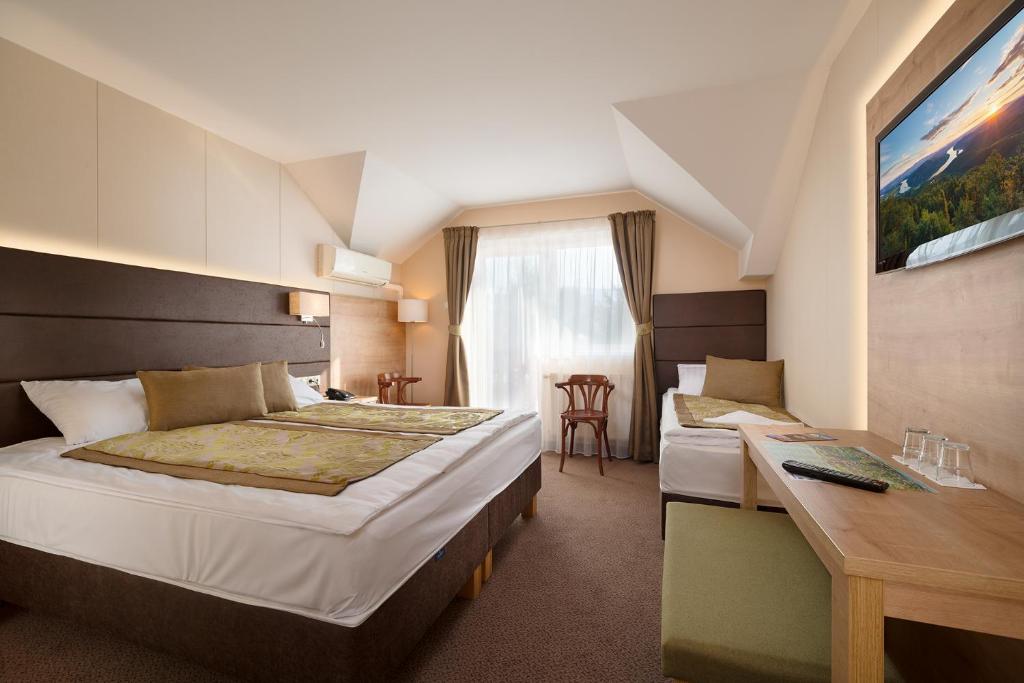 Rúm í herbergi á Hotel Honti Wellness és Konferencia Szálloda