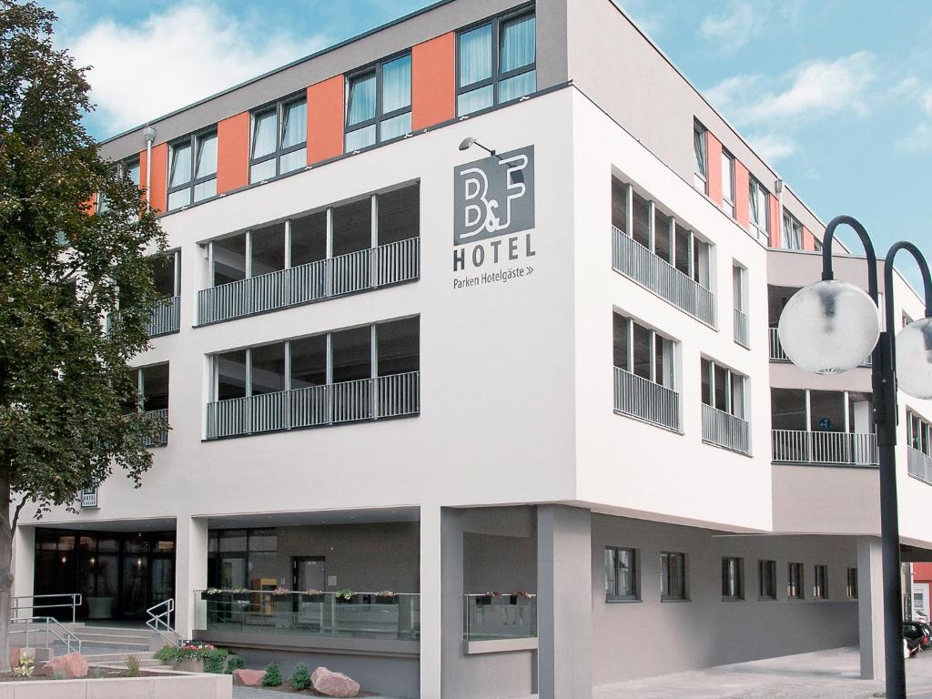 ein weißes Gebäude mit einem Hotelschild drauf in der Unterkunft B&F Hotel am Neumarkt in Bad Hersfeld