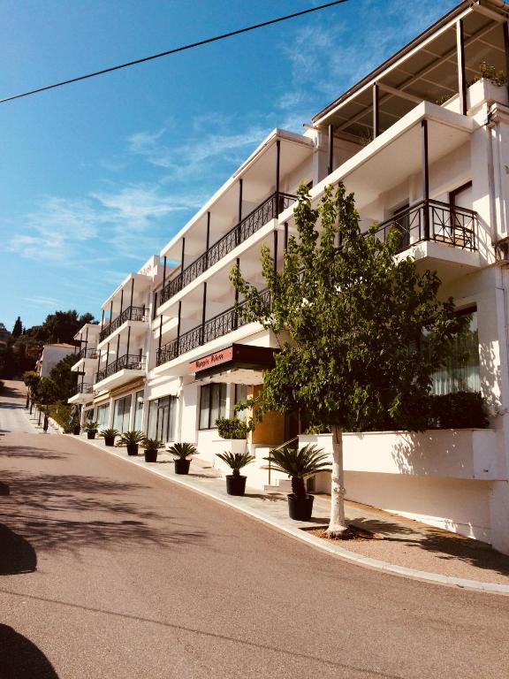 a white building with a tree in front of it at Hotel Olympia Palace in Olympia