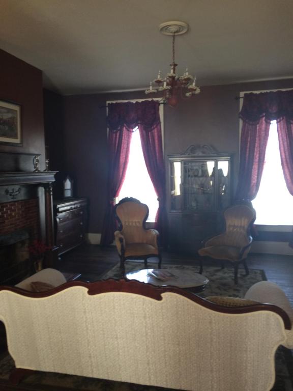 a living room with a couch and two windows at Main Street Bed & Breakfast in Glasgow