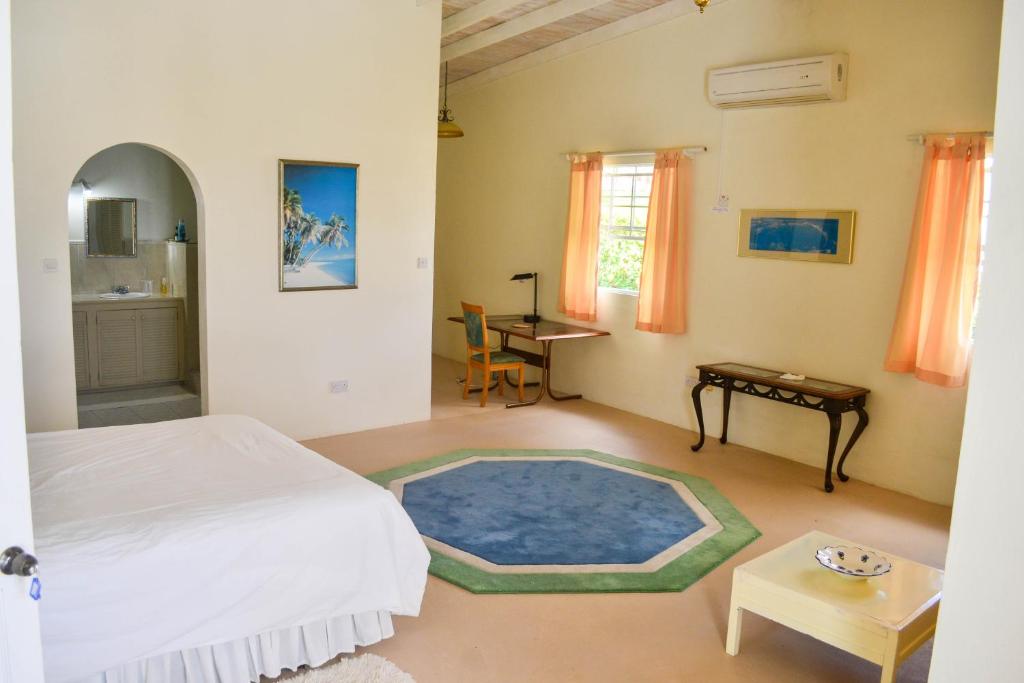 a bedroom with a white bed and a blue rug at Top of the World Apartments in Marisule Estate