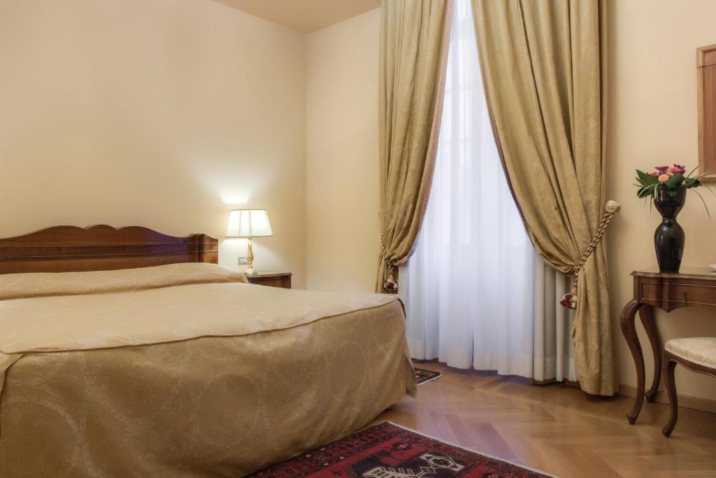 En eller flere senger på et rom på Villa Fenaroli Palace Hotel