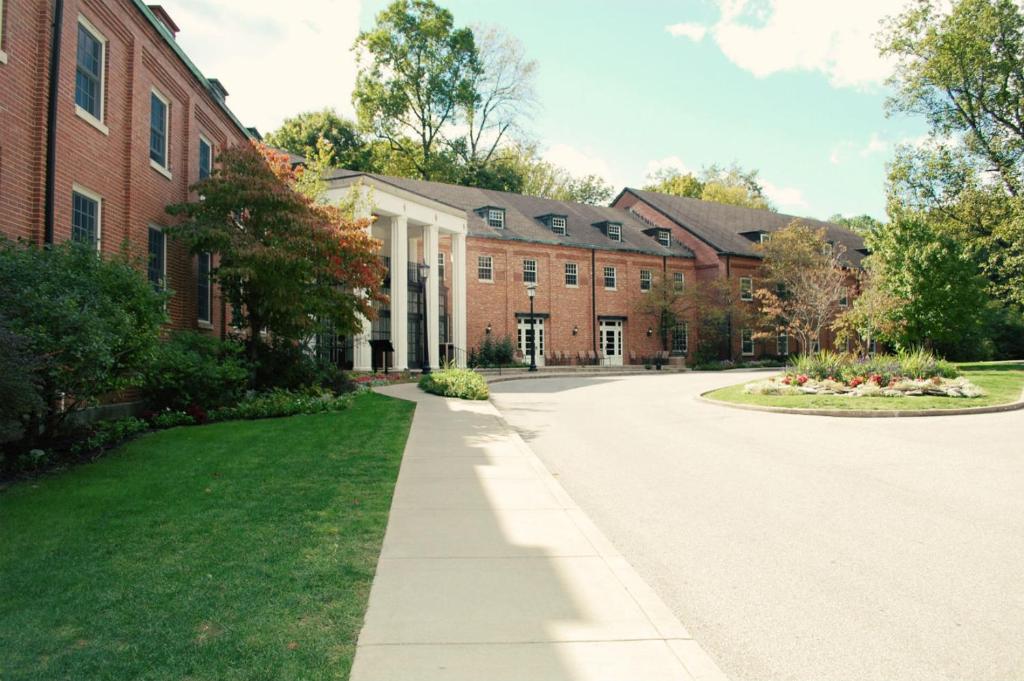 a large red brick building with a driveway at Canyon Inn in Spencer