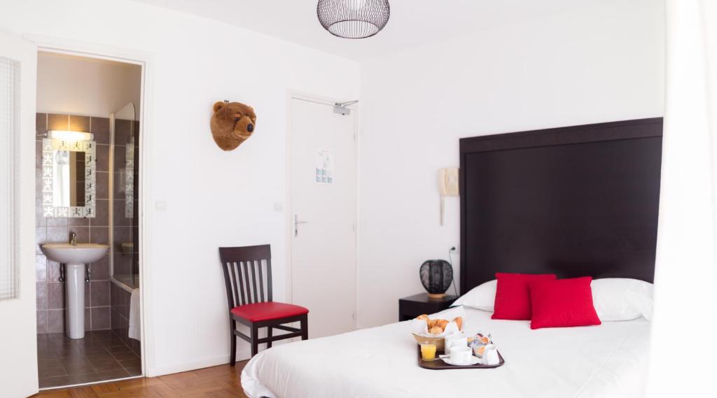 - une chambre avec un grand lit blanc et des oreillers rouges dans l'établissement Esperanto, à Cannes