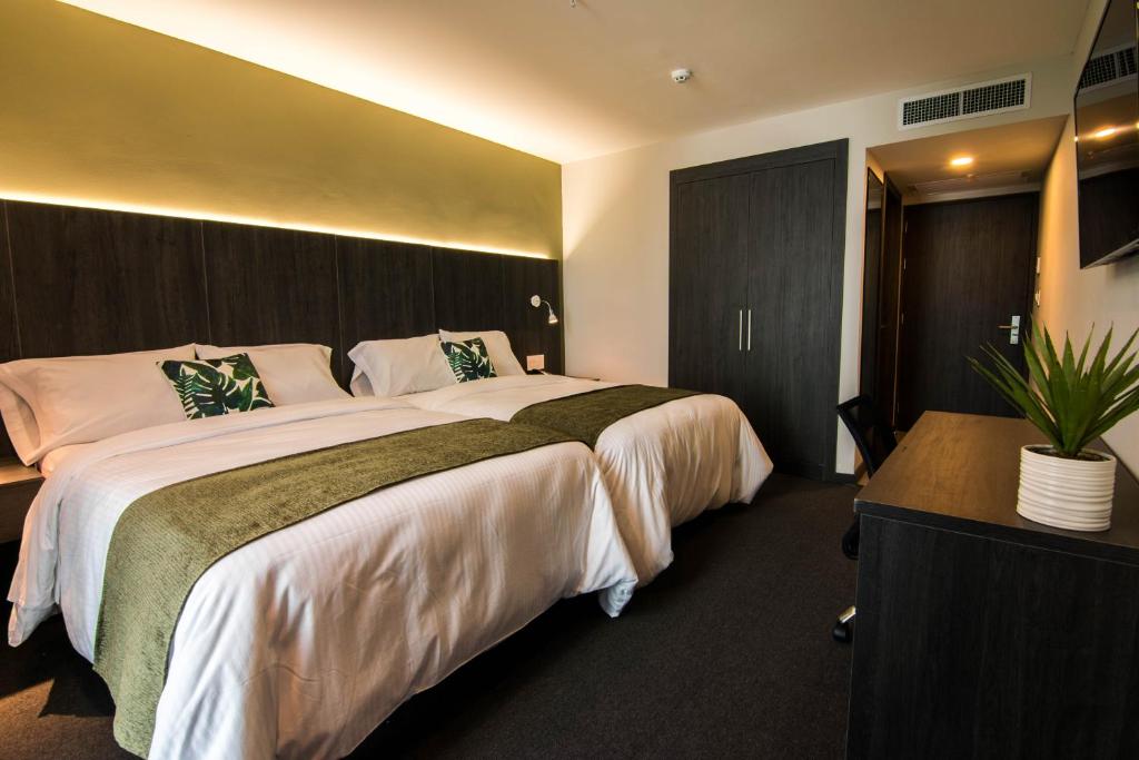 Postel nebo postele na pokoji v ubytování Innfiniti Hotel & Suites