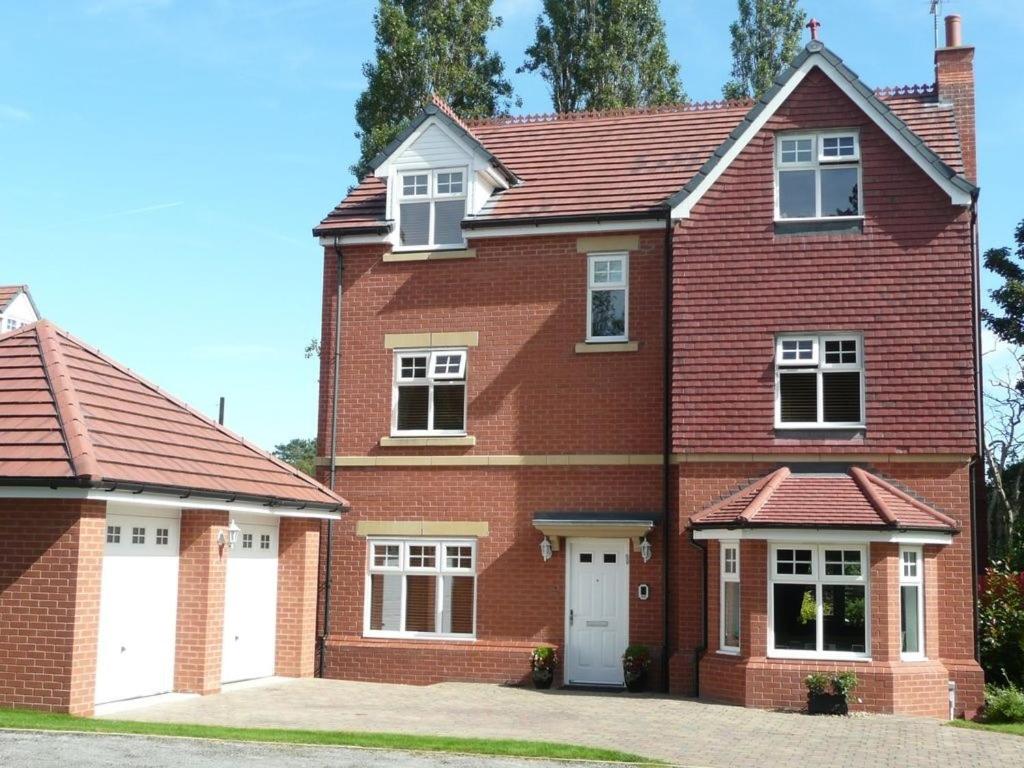 una casa de ladrillo rojo con dos puertas blancas en 2 The Rocklands, en Birkenhead