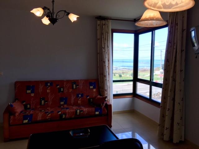 uma sala de estar com um sofá e uma grande janela em Apartamento Con Vistas Al Mar em Villadesuso