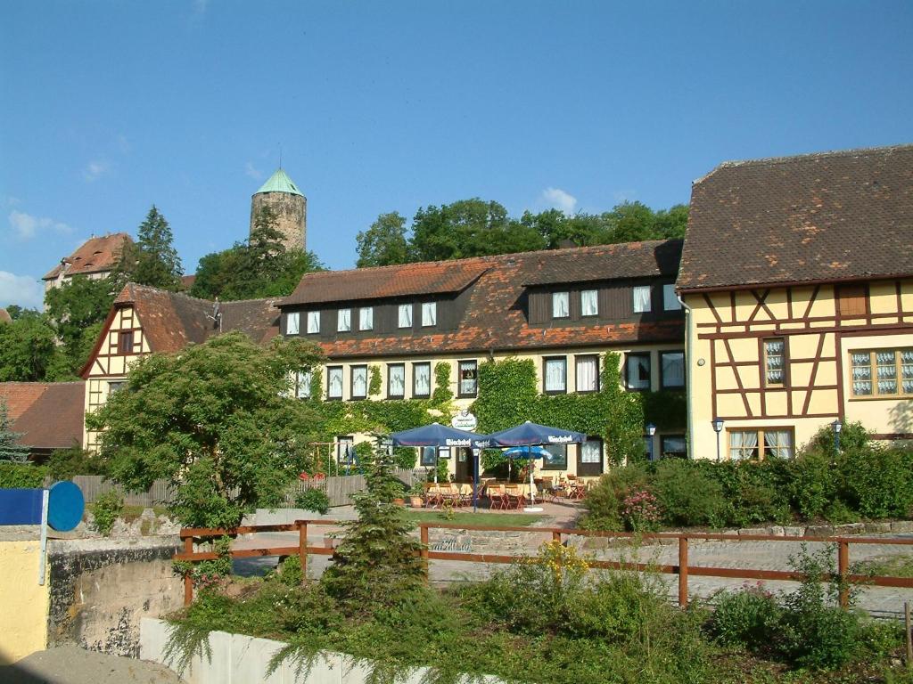 a group of buildings with tables and umbrellas at Gutshof Colmberg in Colmberg