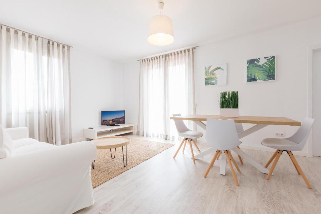 una sala de estar blanca con mesa y sillas en Apartamentos Baltum, en Albufeira