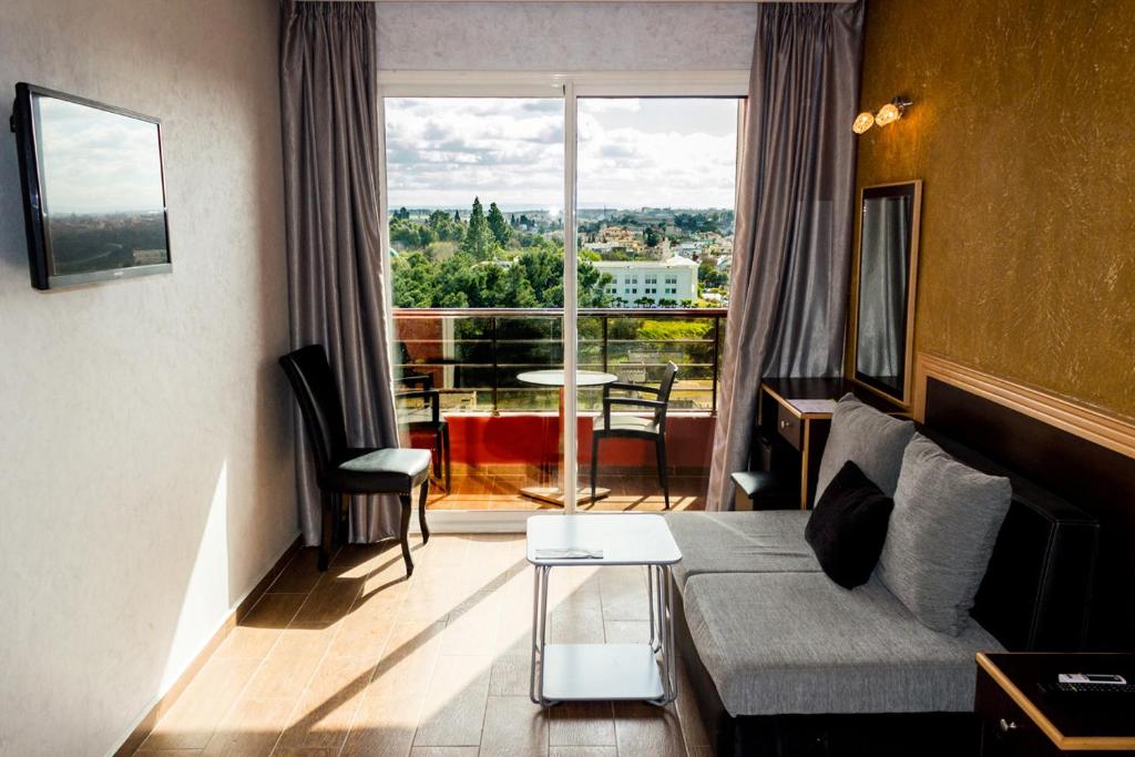 a living room with a couch and a large window at Hôtel Belle Vue et Spa in Meknès