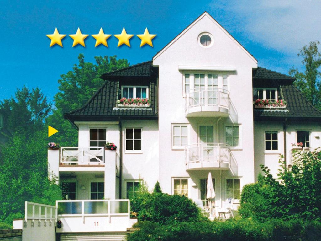 four yellow stars on top of a white house at Sonnige Ferienwohnung am Meer in Travemünde