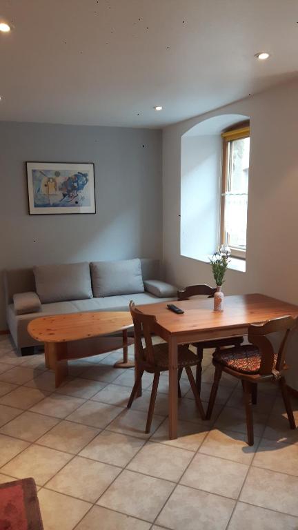 a living room with a wooden table and a couch at Ferienwohnung Hammelburg in Hammelburg