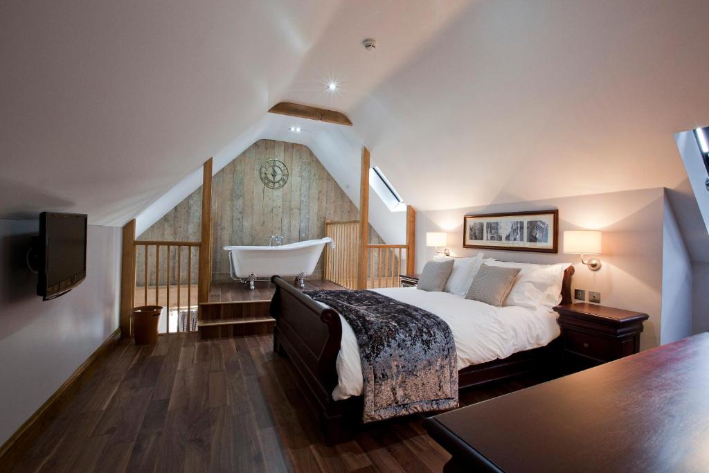 um quarto com uma cama e uma banheira num quarto em The New Inn em Cerne Abbas