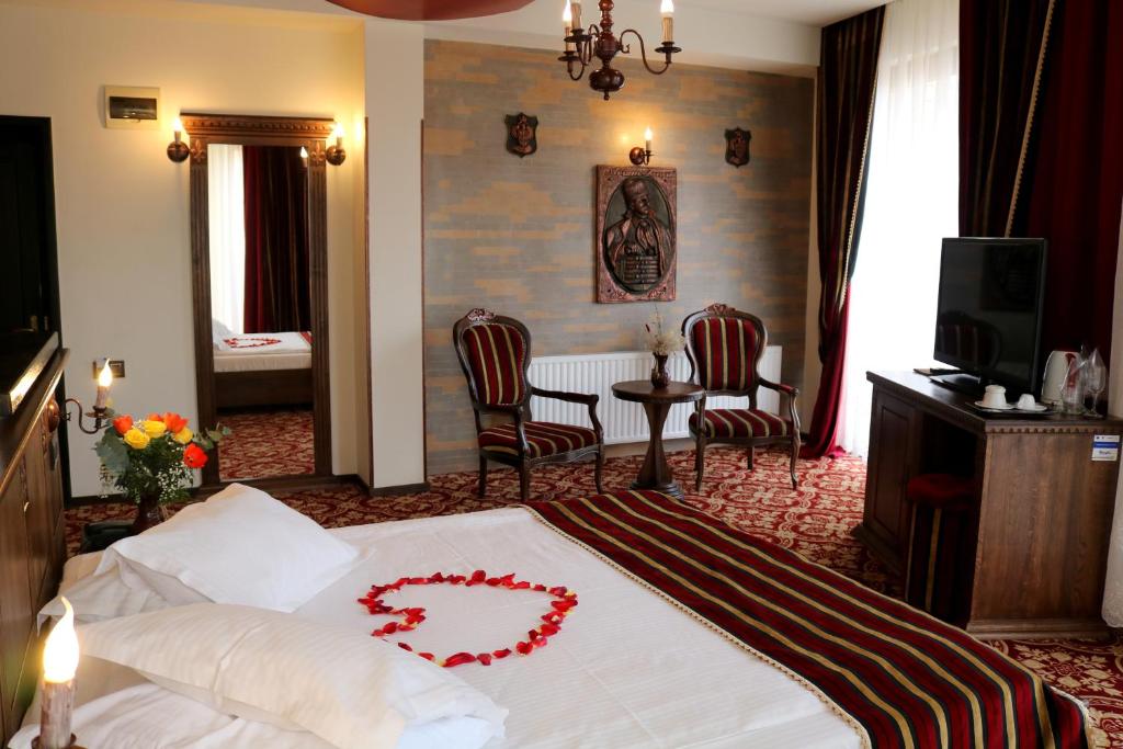 a bedroom with a bed with a heart on it at Castel Transilvania in Baia Mare