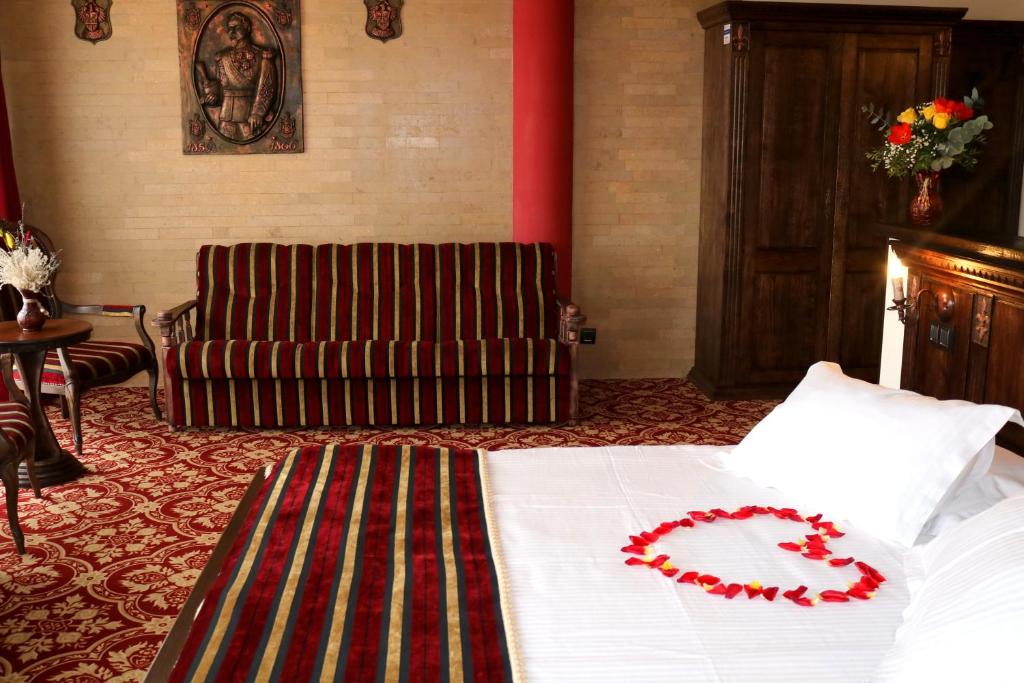 a bedroom with a bed with a red flower on it at Castel Transilvania in Baia Mare