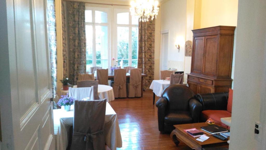 a room with a dining room with tables and chairs at Manoir de la Marjolaine in Cabourg