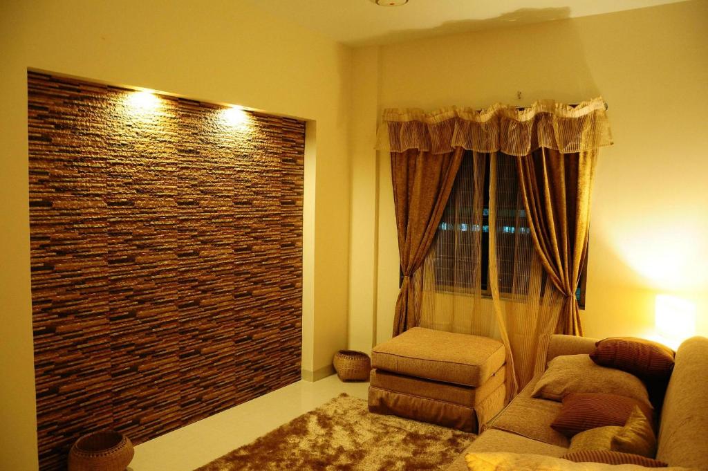 a living room with a couch and a large window at Rajanigandha Family Suites in Dhaka