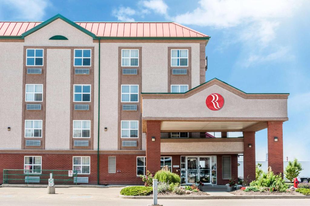 un rendimiento de un edificio de hospital con techo rojo en Ramada by Wyndham Sherwood Park, en Sherwood Park