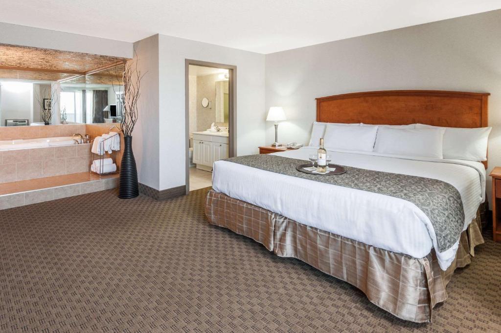 Postel nebo postele na pokoji v ubytování Ramada by Wyndham Edmonton South