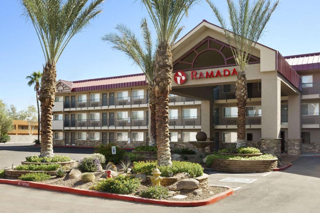 a hotel with palm trees in front of a building at Ramada by Wyndham Tempe/At Arizona Mills Mall in Tempe