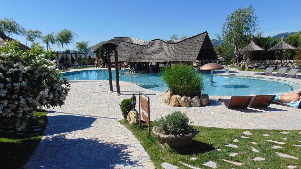 a large swimming pool with chairs and a building at Castel Transilvania in Baia Mare