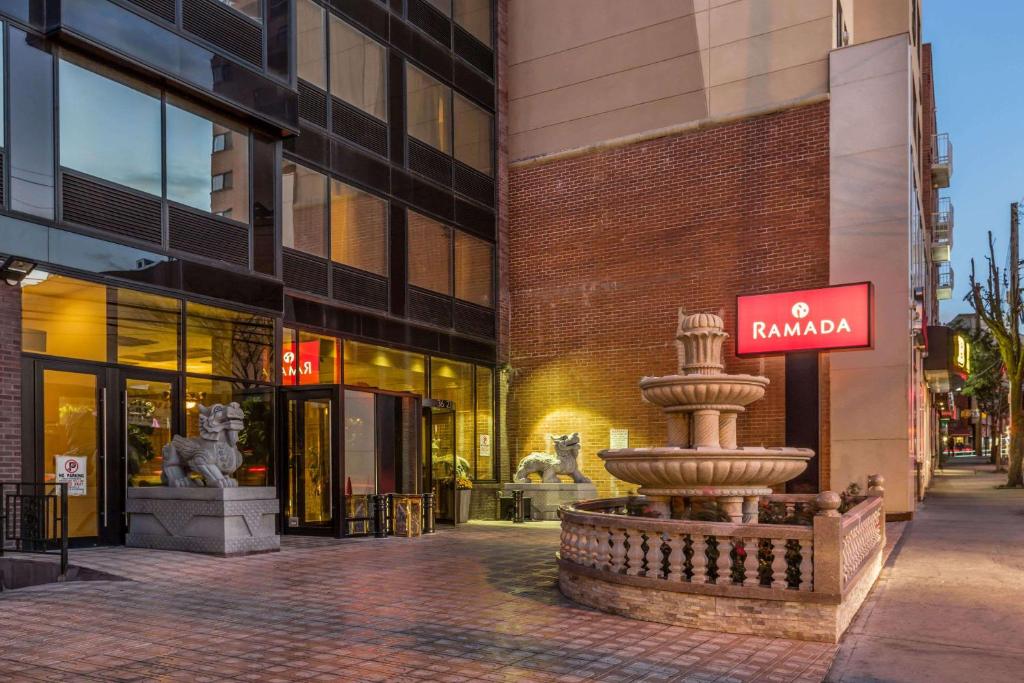 a street with a fountain in front of a building at Ramada by Wyndham Flushing Queens in Queens