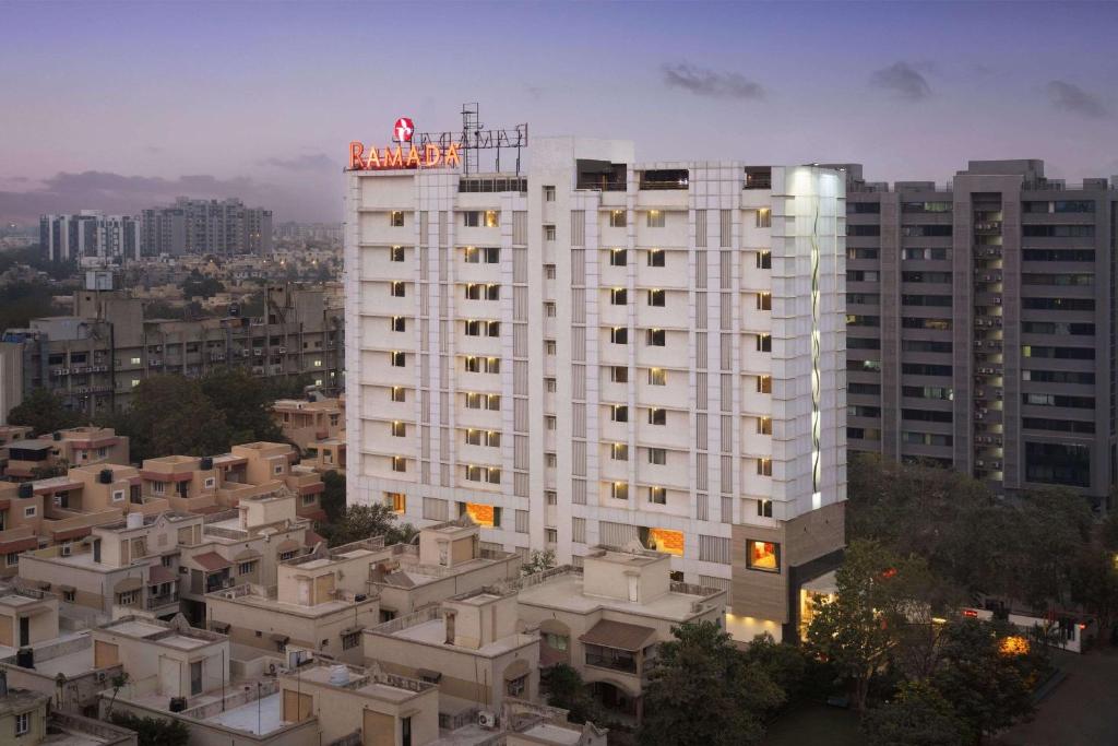 a large white building with a sign on top of it at Ramada Ahmedabad in Ahmedabad