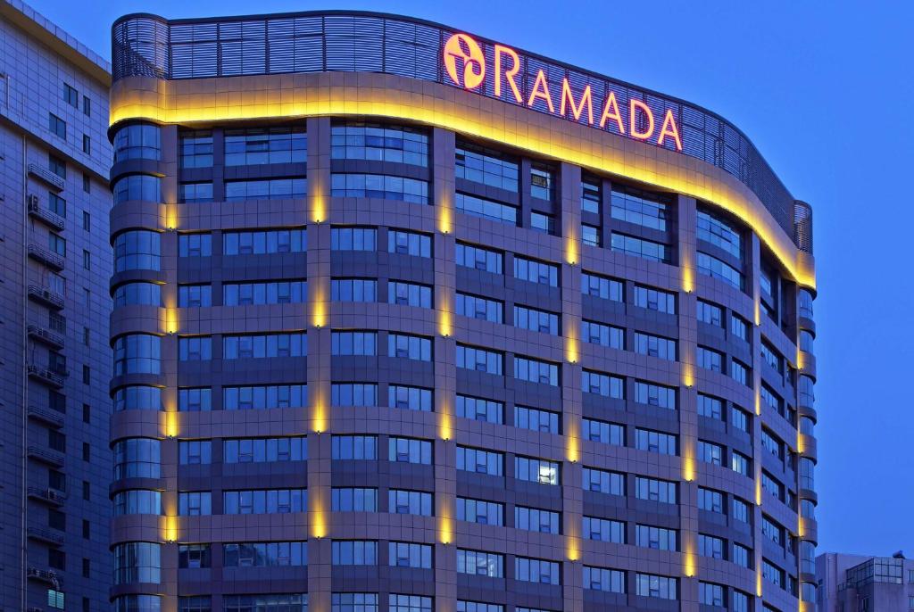 a building with a sign on top of it at Ramada Changzhou North Hotel in Changzhou