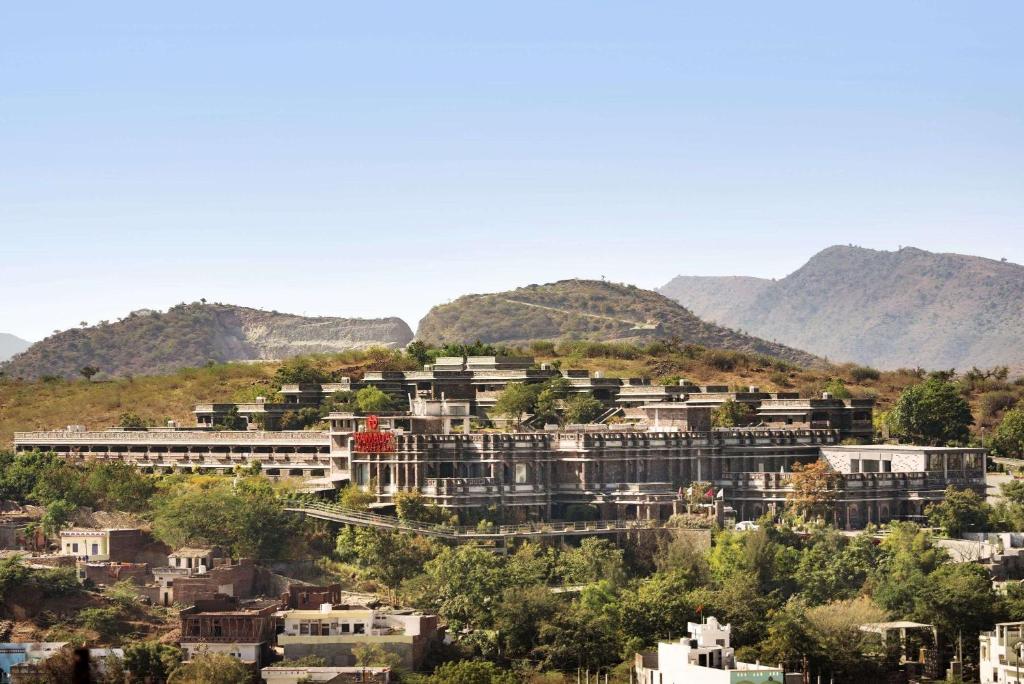 a town on a hill with mountains in the background at Ramada by Wyndham Udaipur Resort and Spa in Udaipur
