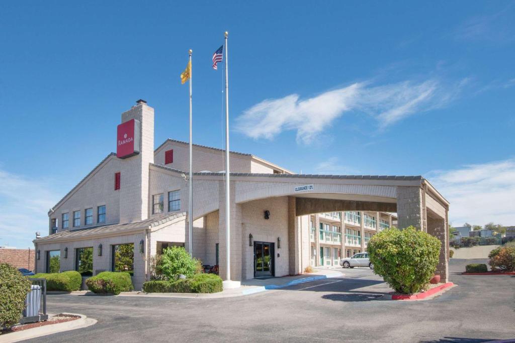 un edificio de oficinas con una bandera encima en Ramada by Wyndham Albuquerque Airport en Albuquerque