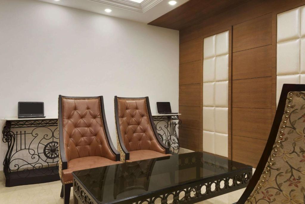 two chairs and a glass table in a room at Ramada Plaza By Wyndham, Chandigarh Zirakpur in Chandīgarh