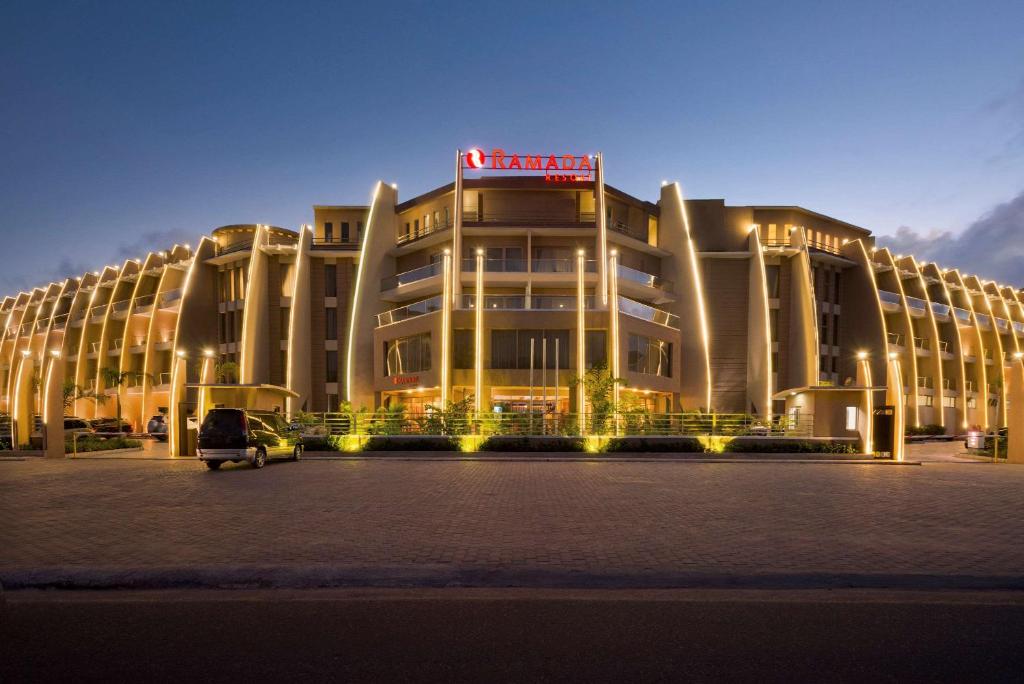 a building with a car parked in front of it at Ramada Resort By Wyndham Dar es Salaam in Dar es Salaam