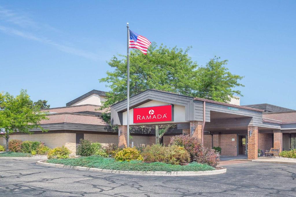 a building with an american flag on top of it at Ramada by Wyndham Waupaca in Waupaca