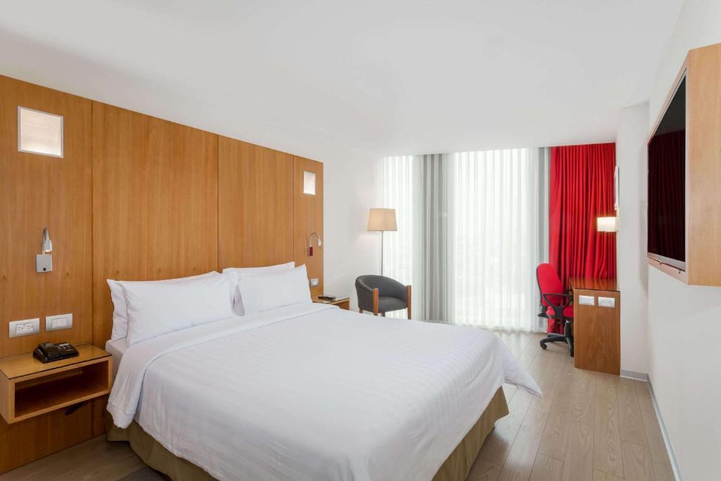 Postel nebo postele na pokoji v ubytování Ramada Encore by Wyndham Lima San Isidro