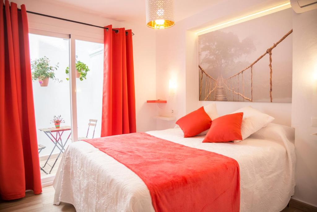 a bedroom with a large bed with red curtains at La Casa Del Recreo in Cómpeta