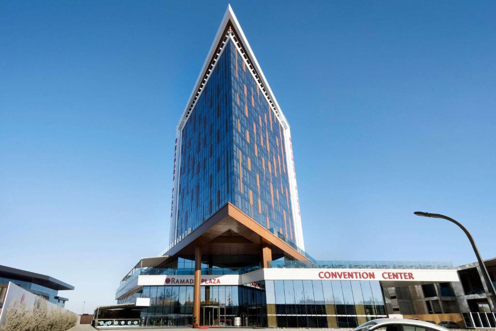 a tall glass building with a pointed roof at Ramada Plaza By Wyndham Konya in Konya