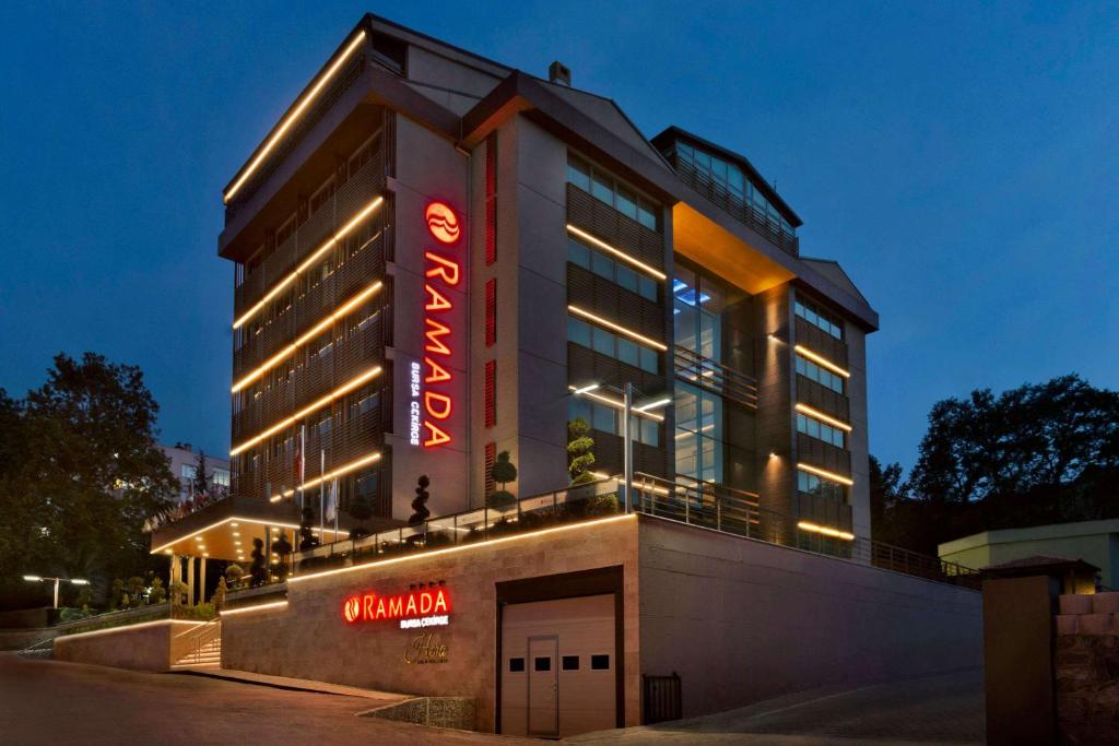 伯薩的住宿－Ramada By Wyndham Bursa Cekirge Thermal & Spa，旁边有一个 ⁇ 虹灯标志的酒店
