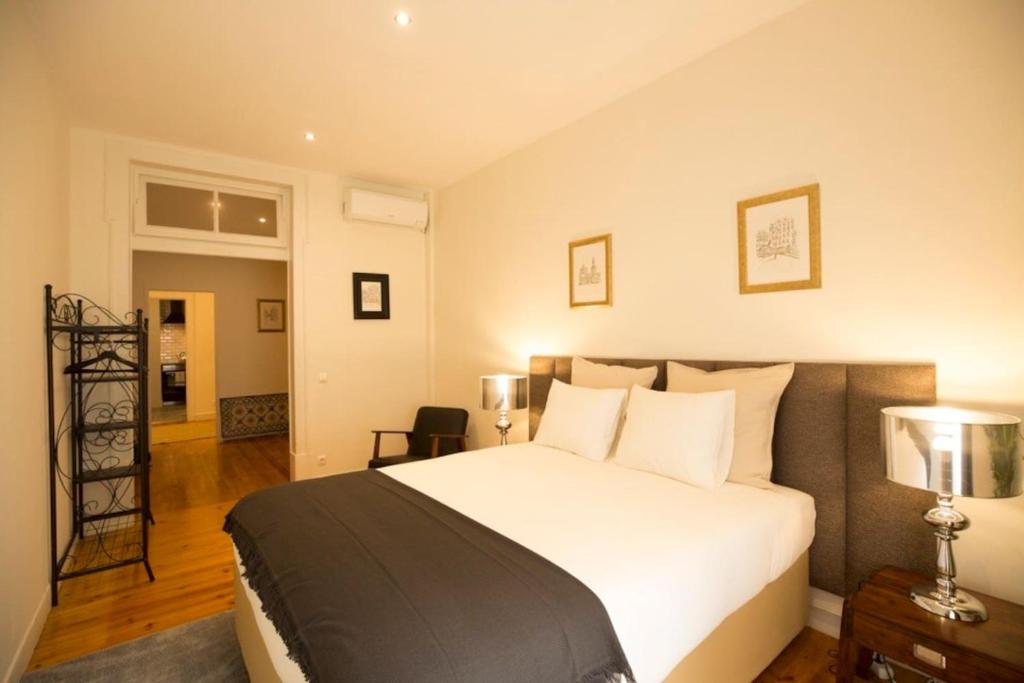 a bedroom with a large white bed with two lamps at Ola Lisbon - Chiado IV in Lisbon